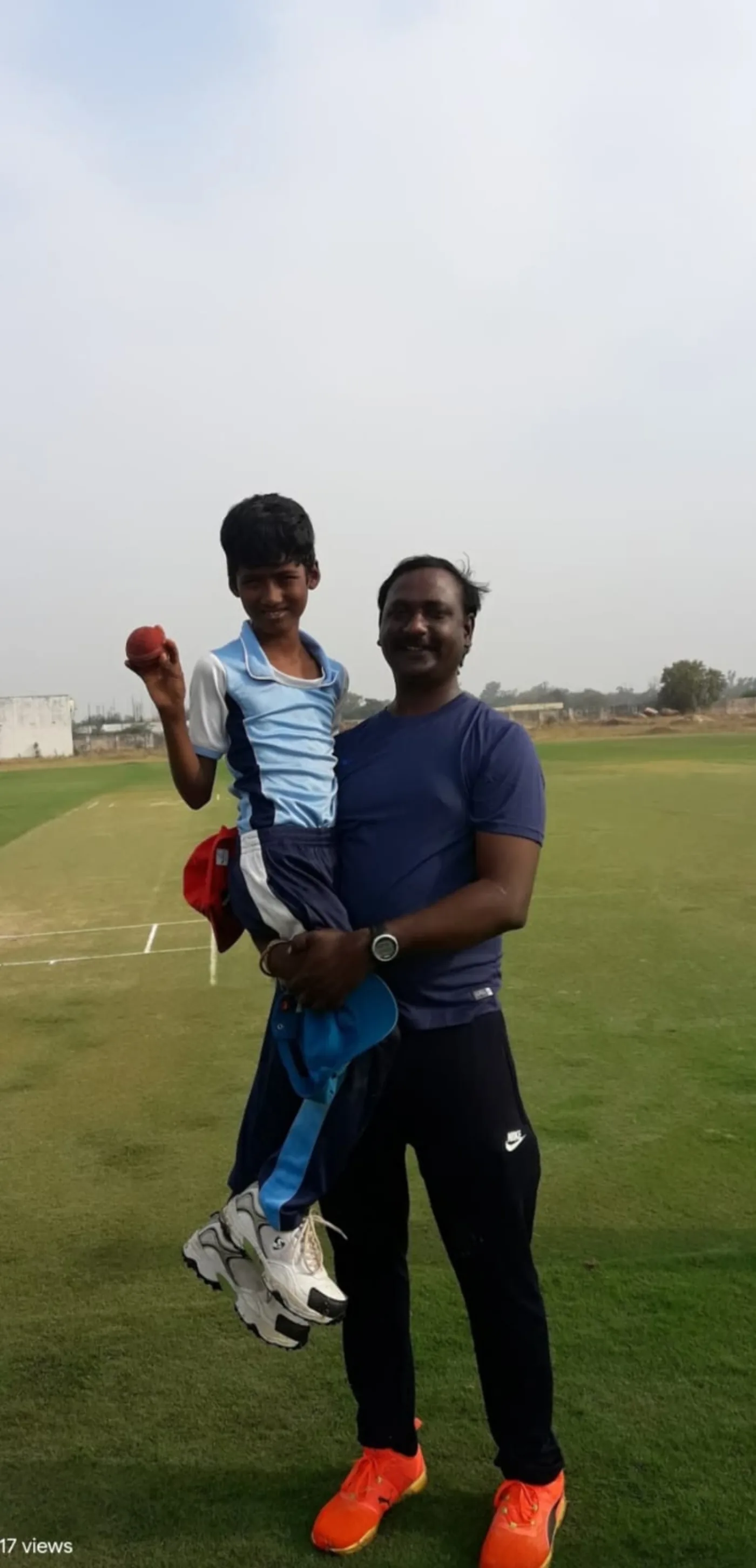Coach standing with a young cricket player
