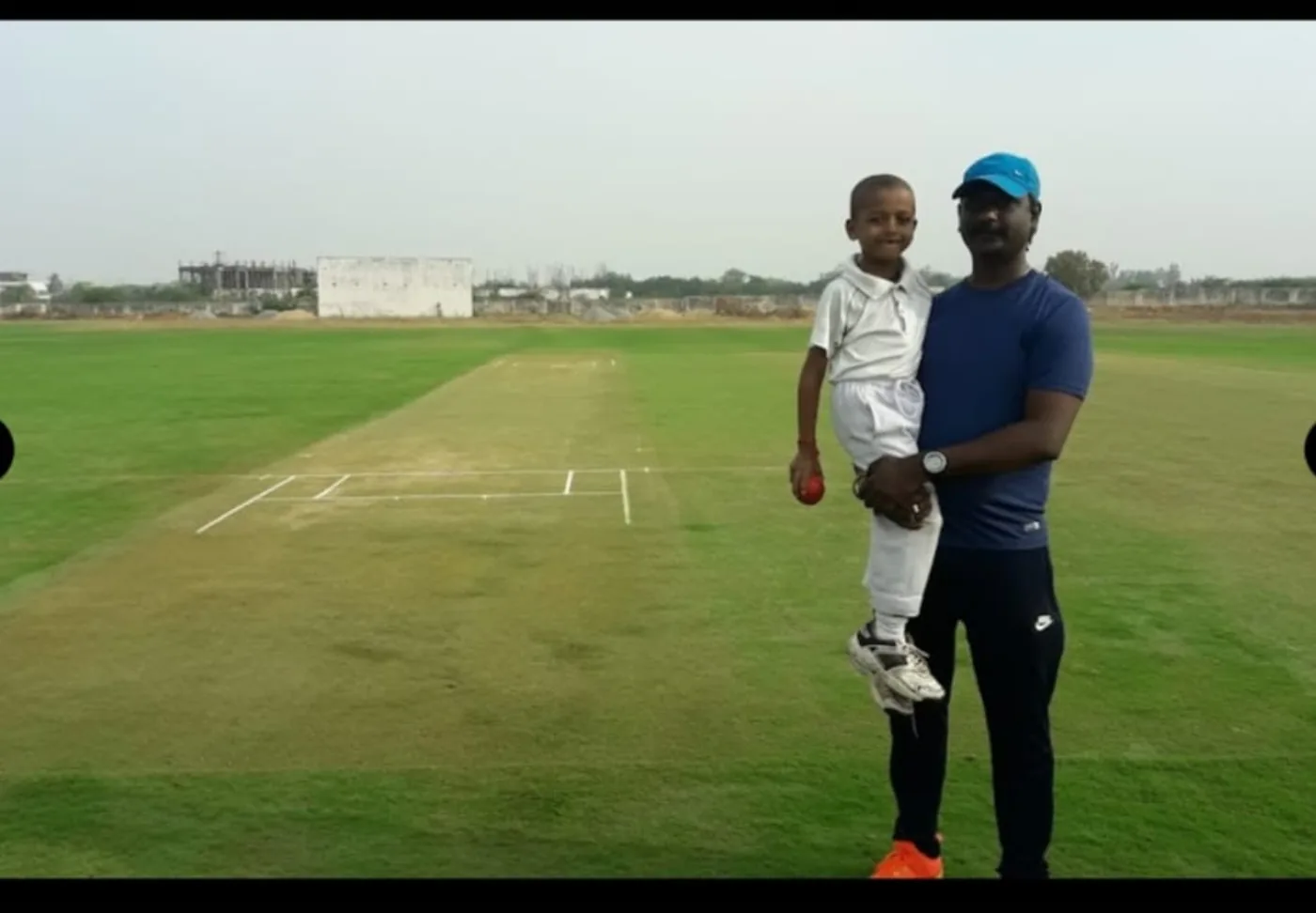 Coach and player on a cricket pitch