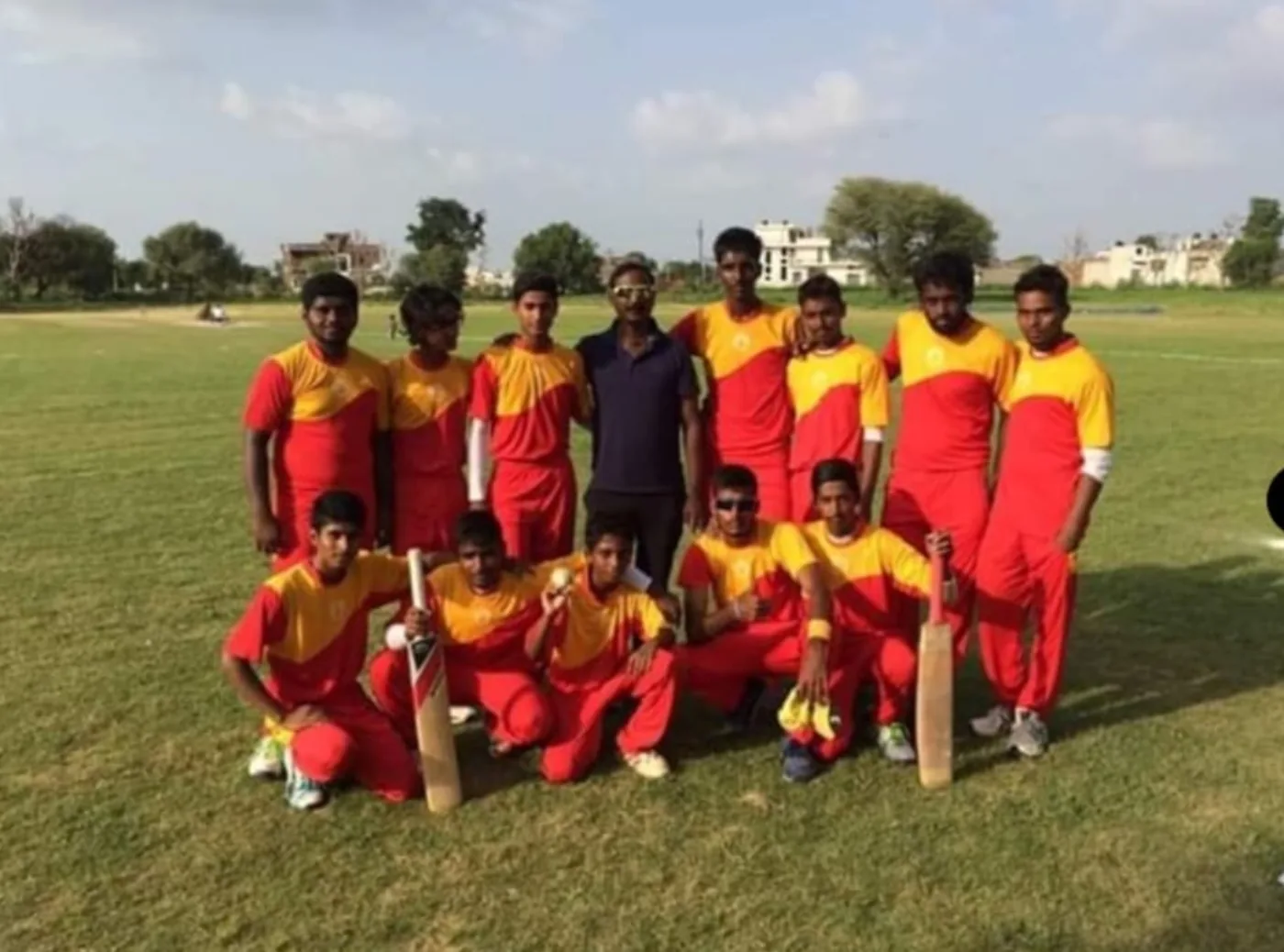 Cricket team in red and yellow uniforms
